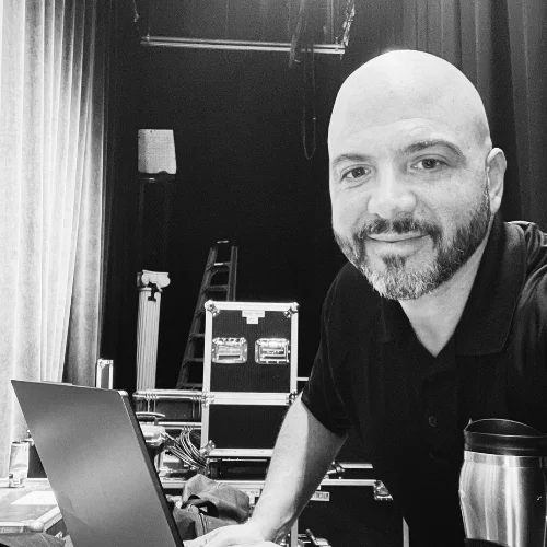 Brian Black backstage at an event, working at a laptop beside a road case